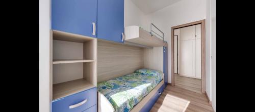 um pequeno quarto com prateleiras azuis e uma cama em Appartamento via volta em Sanremo