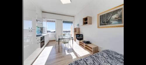 uma cozinha e sala de estar com paredes brancas e uma mesa em Appartamento via volta em Sanremo
