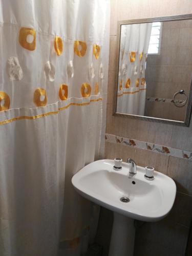 a bathroom with a sink and a shower curtain at Complejo Ayres de Funes in Potrero de los Funes