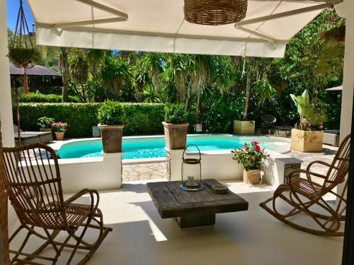 une piscine avec deux chaises et une table dans l'établissement Villa Riviera, à Cannes