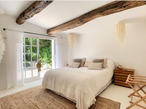a white bedroom with a bed and a window at Villa Riviera in Cannes