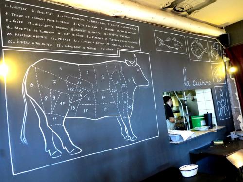 a chalkboard with a drawing of a cow on a wall at Hôtel La Bastide in Hyères
