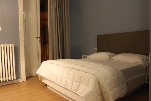 a bedroom with a white bed and a radiator at Boutique Hotel Palazzo Corso Umberto in Boiano