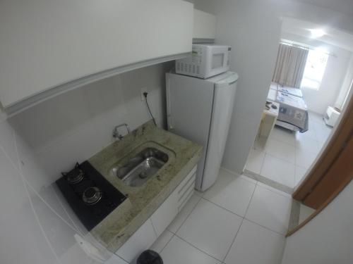 a small kitchen with a sink and a microwave at Israel Flat in João Pessoa