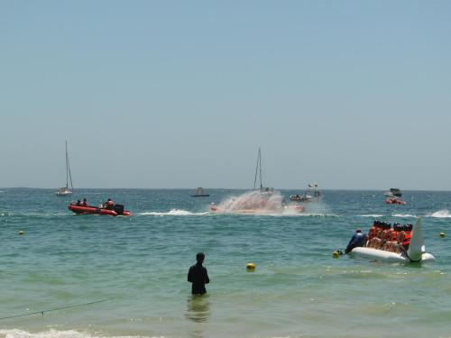 a man standing in the water at the beach with boats at Cabañas Mirador de Soledad in El Quisco