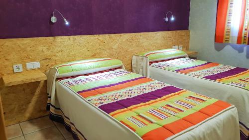 two beds are in a room with purple and purple at Hs San Francisco - CÉNTRICO in Almagro