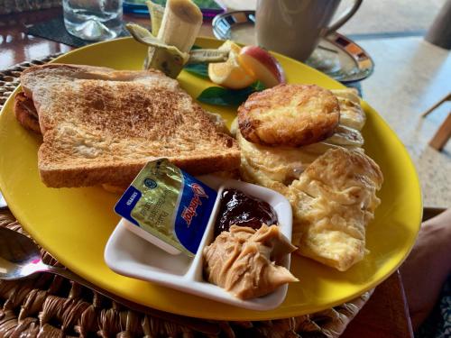 a yellow plate of breakfast food with eggs and toast at Taveuni Dive Resort in Waiyevo