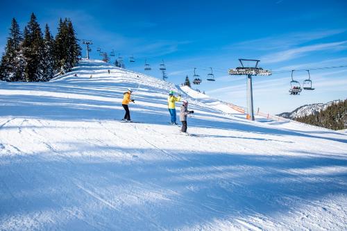 a group of people on a ski slope with a ski lift at Kinderhotel Appelhof in Mürzsteg