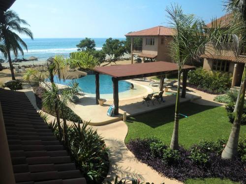 a view of a resort with a swimming pool and the ocean at Las Villas, Villa Alegria,Troncones in Troncones