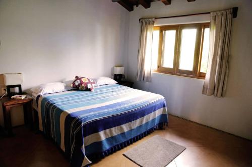 1 dormitorio con 1 cama con manta azul y blanca en Las Villas, Villa Alegria,Troncones, en Troncones