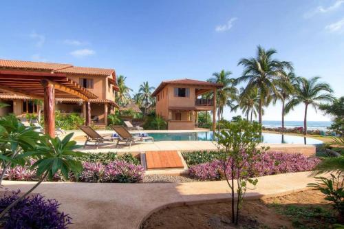 a resort with a swimming pool and palm trees at Las Villas, Villa Alegria,Troncones in Troncones