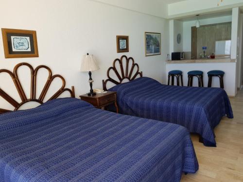 two beds in a hotel room with blue sheets at Salvia Cancun Aparts in Cancún
