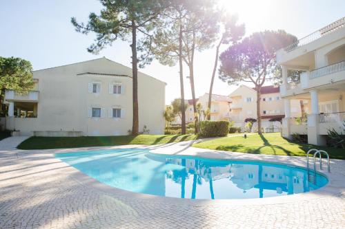 a swimming pool in front of a building at Loving Tróia in Troia