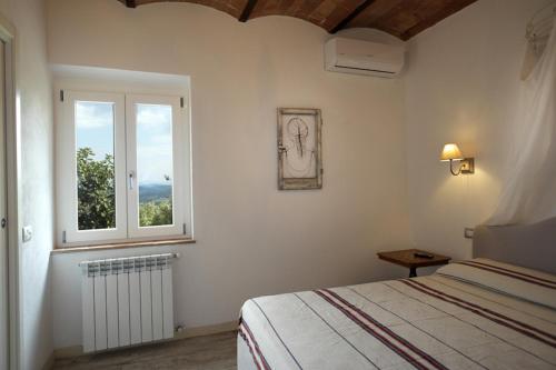 Schlafzimmer mit einem Bett und einem Fenster in der Unterkunft Casa Del Principe in Gambassi Terme