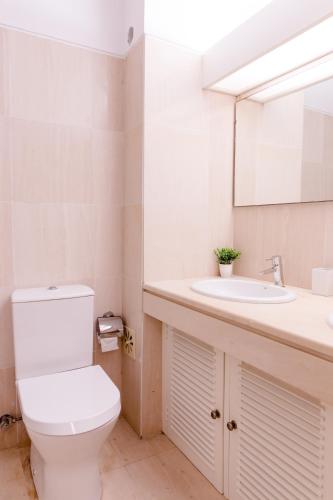 a bathroom with a toilet and a sink at Loving Tróia in Troia