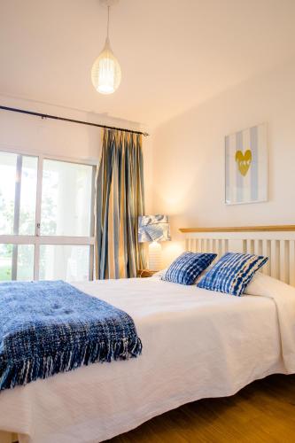a bedroom with a large bed and a window at Loving Tróia in Troia