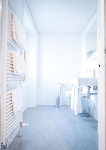 a white bathroom with a sink and a mirror at Bed&Bike Tremola San Gottardo in Airolo