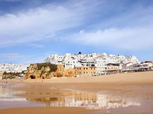 a view of a beach with a town in the background at Sea View Downtown - Albufeira in Albufeira