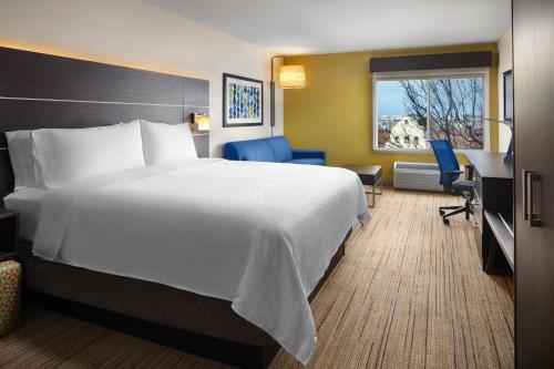 a hotel room with a large bed and a desk at Holiday Inn Express Hotel & Suites Belmont by IHG in Belmont