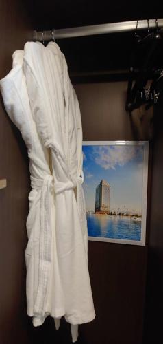 a white robe hanging on a wall with a picture at Western Bay Marina Hotel in Pyeongtaek
