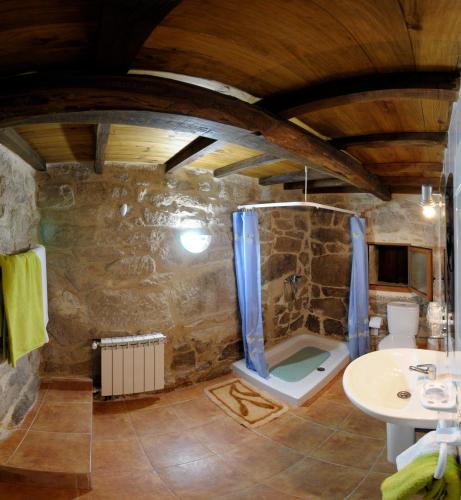 a stone bathroom with a shower and a sink at Casa Dos Fuelles in Ourense