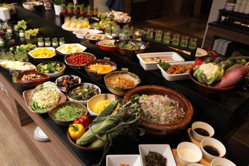 una línea de buffet con muchos platos diferentes de comida en Quintessa Hotel Sapporo en Sapporo