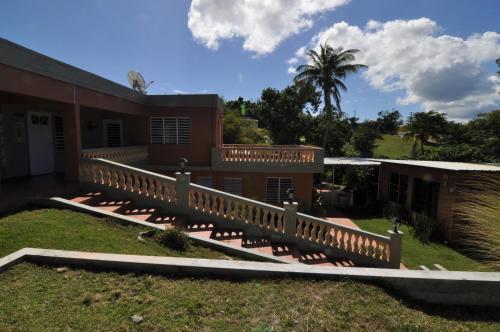 a house with a wooden deck in the yard at Isla Hermosa Guesthouse in Vieques