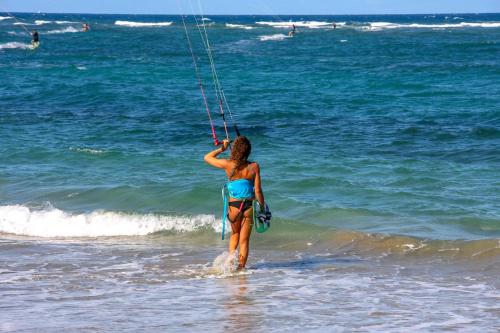 a woman is standing in the water on the beach at Residencial Mañanero in Cabarete