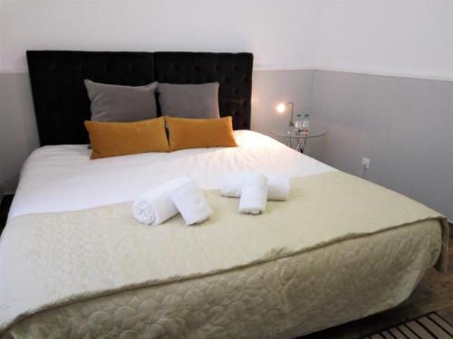 a bed with a white blanket and pillows on top of it at Faro Cosy Guesthouse in Faro