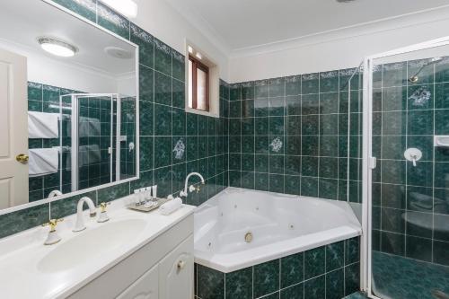 a white bath tub sitting next to a white sink at Best Western Ambassador Motor Inn & Apartments in Wagga Wagga