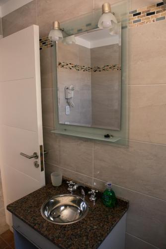 a bathroom with a sink and a mirror at Apart Sabina del Mar in Mar de Ajó