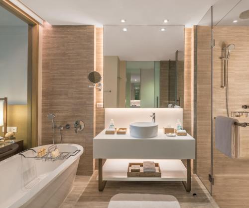 a bathroom with a sink and a tub and a shower at Crimson Resort and Spa Boracay in Boracay