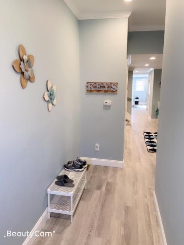 a hallway with white walls and a table with shoes at EN SUITE NEXT TO FELLS POINT in Baltimore