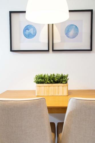 a dining room table with two chairs and a potted plant at Ariama Serviced Residence in Jakarta