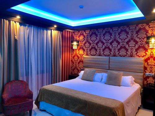 Un dormitorio con una cama con una luz azul. en Hotel Años 50 en Torremolinos