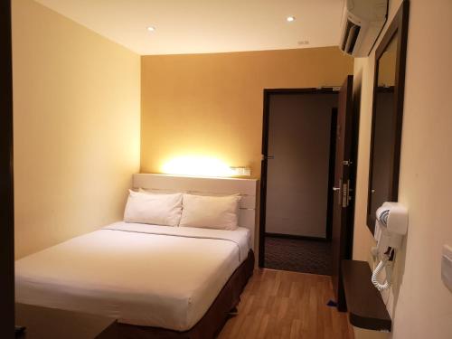 a bedroom with a bed with a light on the wall at Seasons View Hotel in Kuantan
