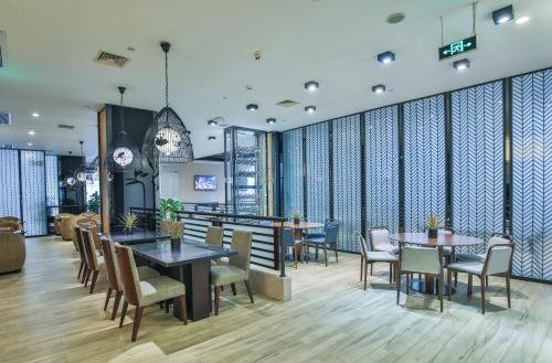 a restaurant with tables and chairs and a clock at SSAW Boutique Hotel Hangzhou Xixi Xin in Hangzhou