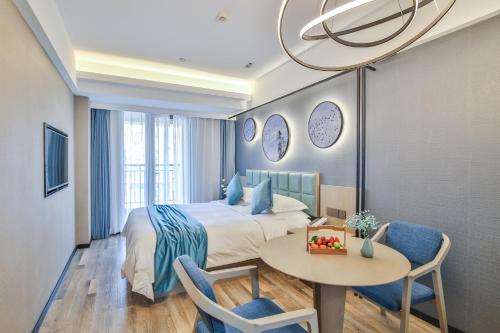 a hotel room with a bed and a table and chairs at SSAW Boutique Hotel Hangzhou Xixi Xin in Hangzhou