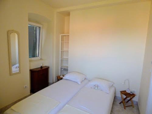1 dormitorio con 2 camas blancas y ventana en House Pod Humom en Jelsa