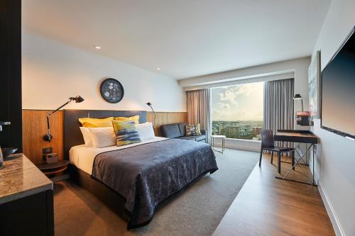 pokój hotelowy z łóżkiem i dużym oknem w obiekcie The Grand by SkyCity w Auckland