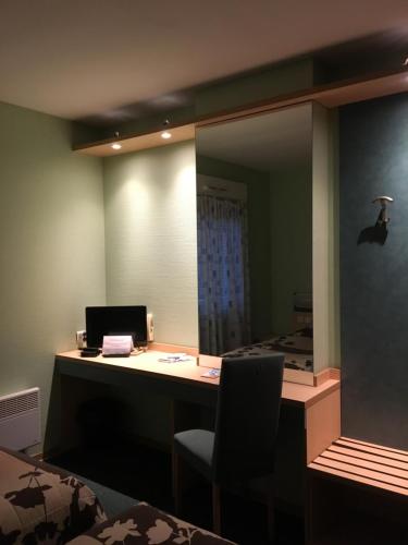 an office with a desk with a computer and a chair at Hôtel Restaurant de L'Europort in Saint-Avold