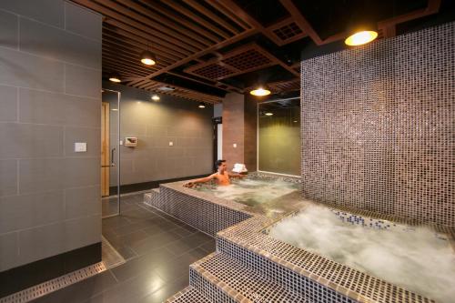 a woman in a hot tub in a bathroom at Grandiose Hotel & Spa in Hanoi