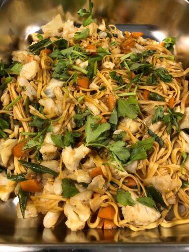 a plate of food with noodles and vegetables at Hotel Rose Hill in Yangon