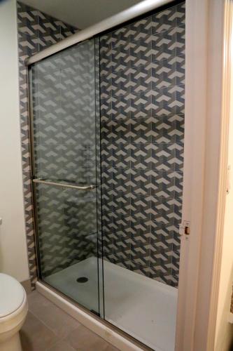 a glass shower in a bathroom with a toilet at The Occidental Lodge in Occidental