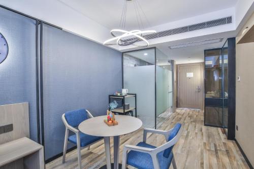 a dining room with a table and blue chairs at SSAW Boutique Hotel Hangzhou Xixi Xin in Hangzhou