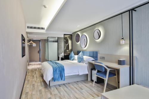 a bedroom with a bed and a desk and a table and chair at SSAW Boutique Hotel Hangzhou Xixi Xin in Hangzhou