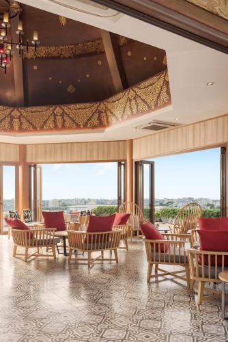 a room with chairs and tables and windows at Mida Grande Hotel Dhavaravati Nakhon Pathom - SHA PLUS in Nakhon Pathom
