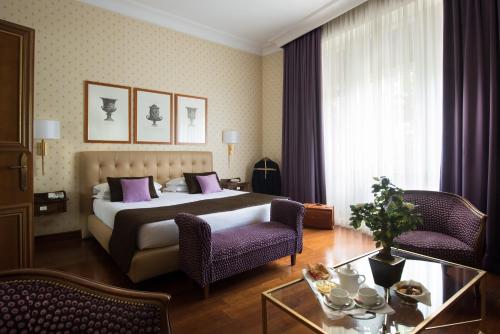 Hotel Imperiale by OMNIA hotels في روما: غرفة نوم بسرير وكرسيين وطاولة