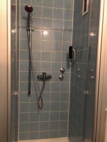 a bathroom with a shower with blue tiles at Gästehaus Hotel Wilms in Cologne