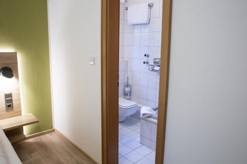 a bathroom with a toilet and a shower in it at Gästehaus Hotel Wilms in Cologne